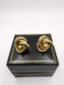 A pair of yellow metal (tested as 18ct carat yellow gold) knot design stud earrings. Dia 1.6cm.