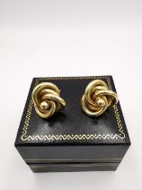 A pair of yellow metal (tested as 18ct carat yellow gold) knot design stud earrings. Dia 1.6cm.
