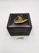 Two 18ct gold charms, a filigree wirework sailing boat and a chilli pepper. Both stamped 18ct. L.2.