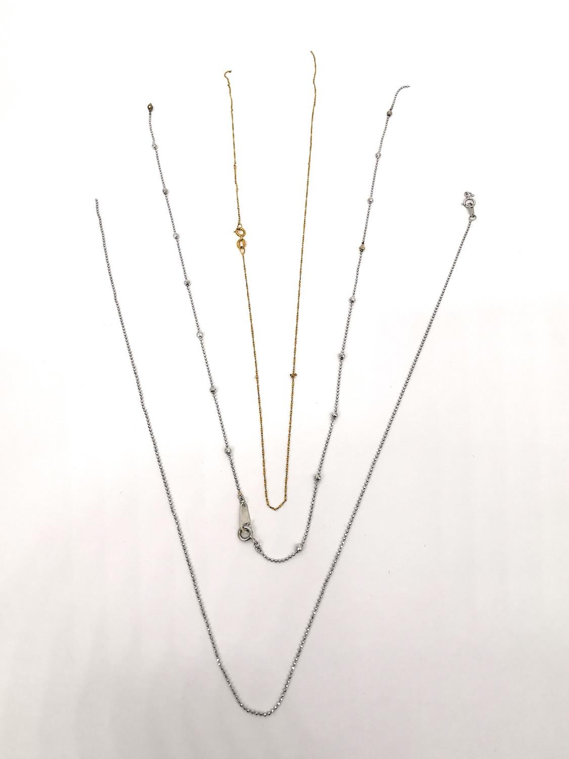 Three broken gold chain link necklaces. A 14ct white gold ball link chain. (Weight 1.50g). An 18ct