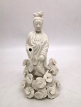 A Chinese 19th century blanc de chine figure of Guanyin surrounded by stylised clouds. H.21 W.11cm.