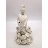 A Chinese 19th century blanc de chine figure of Guanyin surrounded by stylised clouds. H.21 W.11cm.