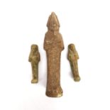 Three Egyptian-style clay ushabti figures, one larger and two small. Each one with incised