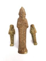 Three Egyptian-style clay ushabti figures, one larger and two small. Each one with incised