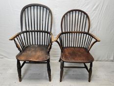 Two 19th century elm seated hoop back Windsor armchairs on turned and stretchered supports.