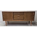 A 1970's vintage sideboard in composite laminated faux teak. H.66 W.135 D.38cm.