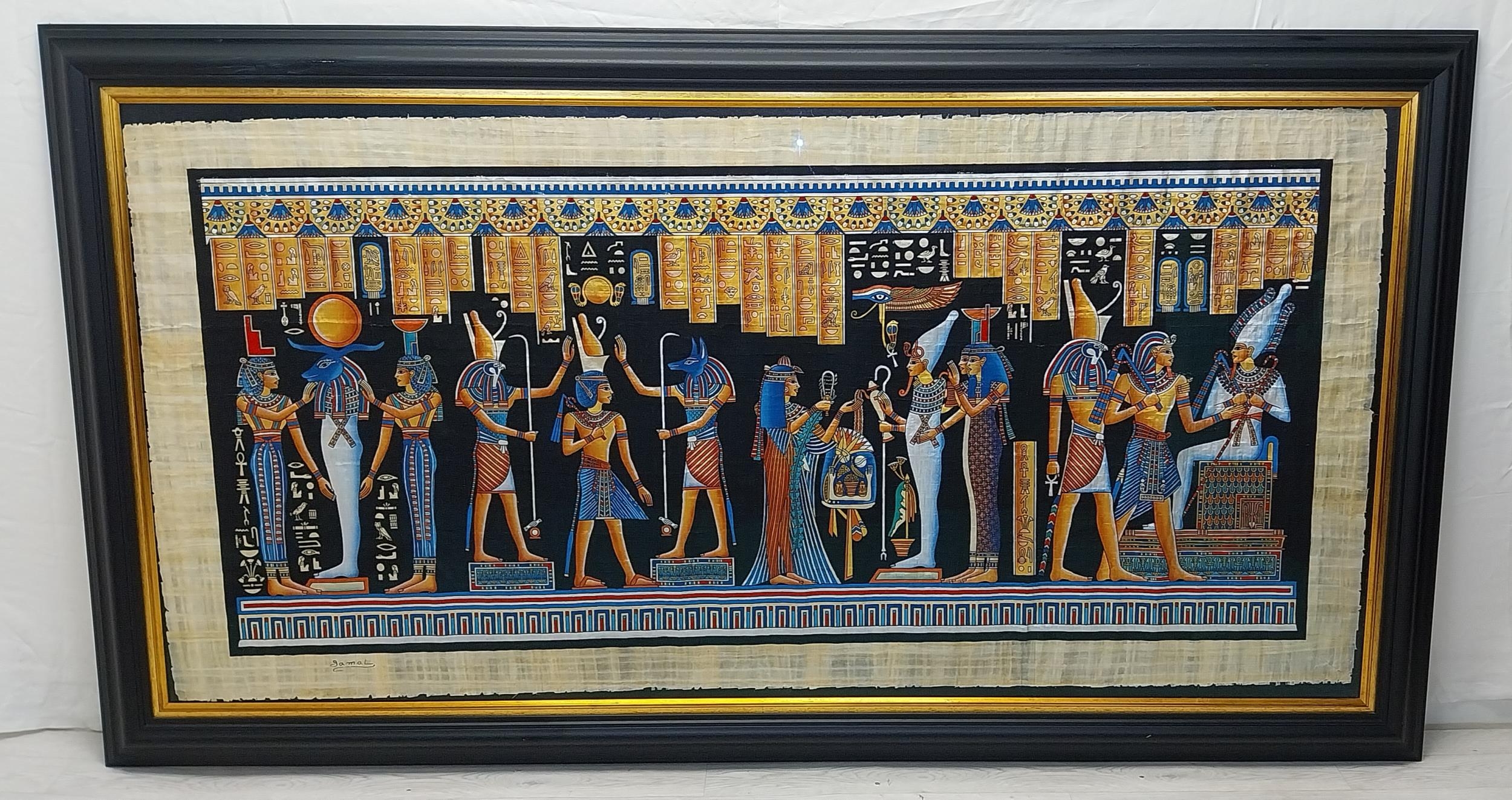 A very large Egyptian painting on papyrus, signed Jamal, framed and glazed. H.114 W.219cm.