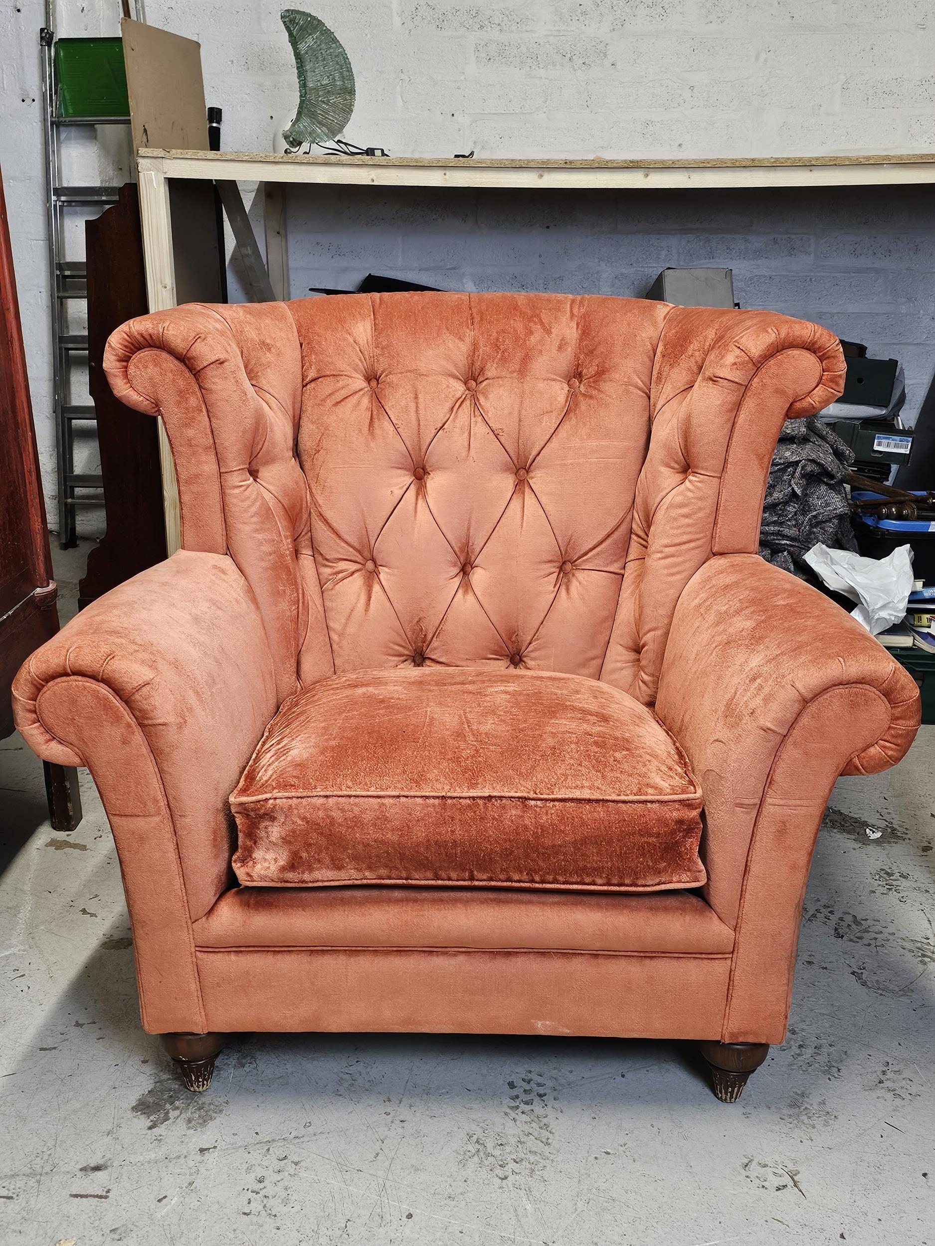 An outsize wing back armchair in deep buttoned upholstery.