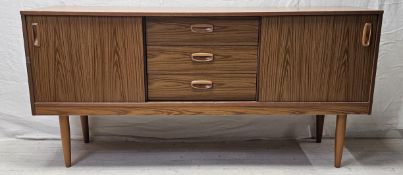 A 1970's vintage sideboard in composite laminated faux teak. H.66 W.135 D.38cm.