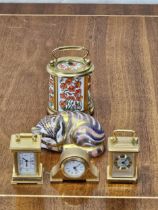 A Crown Derby sleeping cat and four Halcyon Days miniature clocks. Cat is 8cm long.