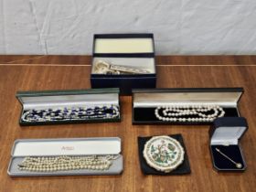 A collection of jewellery, including a yellow metal stick pin set with a white stone, a lapis and