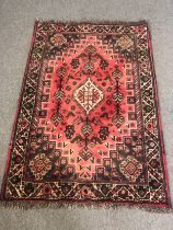 A Shiraz rug, central lozenge medallion on a blush ground within stylised spandrels and multiple