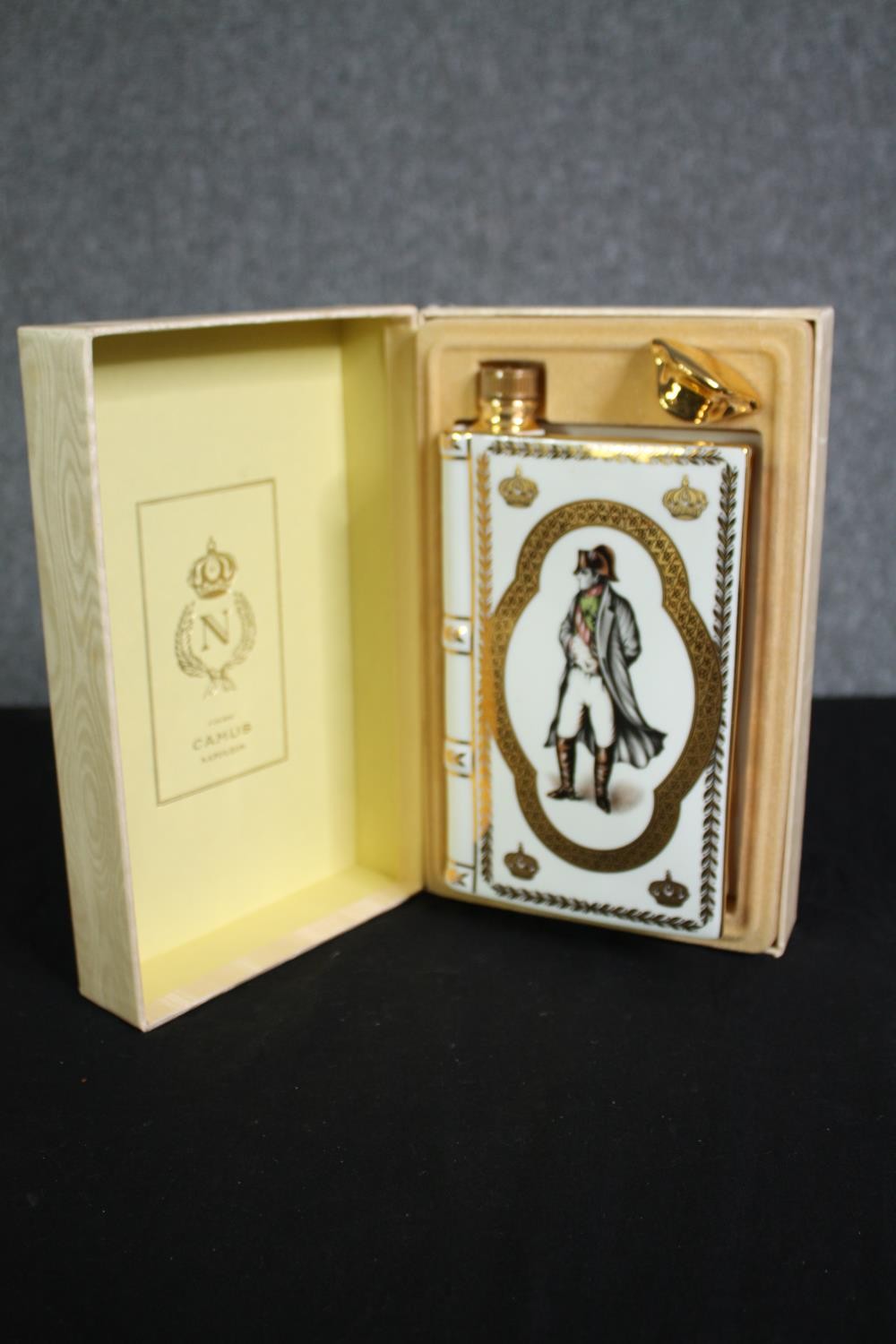 A boxed porcelain flask by Limoges containing Camus Cognac Napoleon brandy. H.25 W.16 D.8cm.