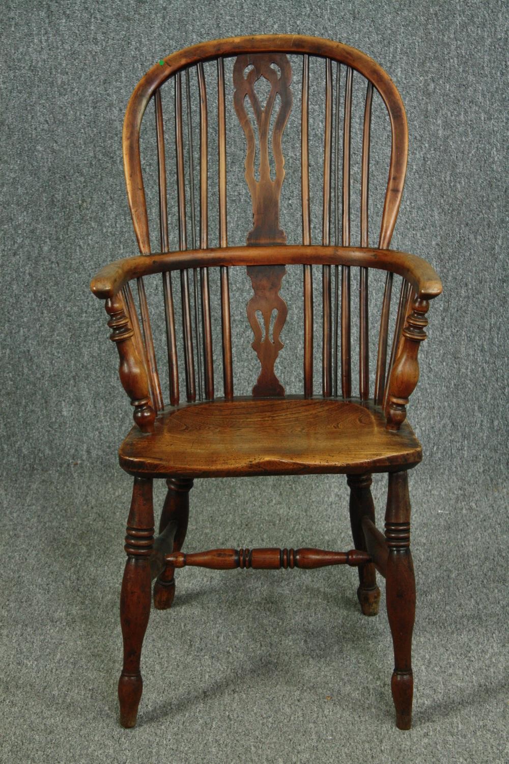 A 19th century elm and yew Windsor armchair with hooped back and pierced splat on turned stretchered