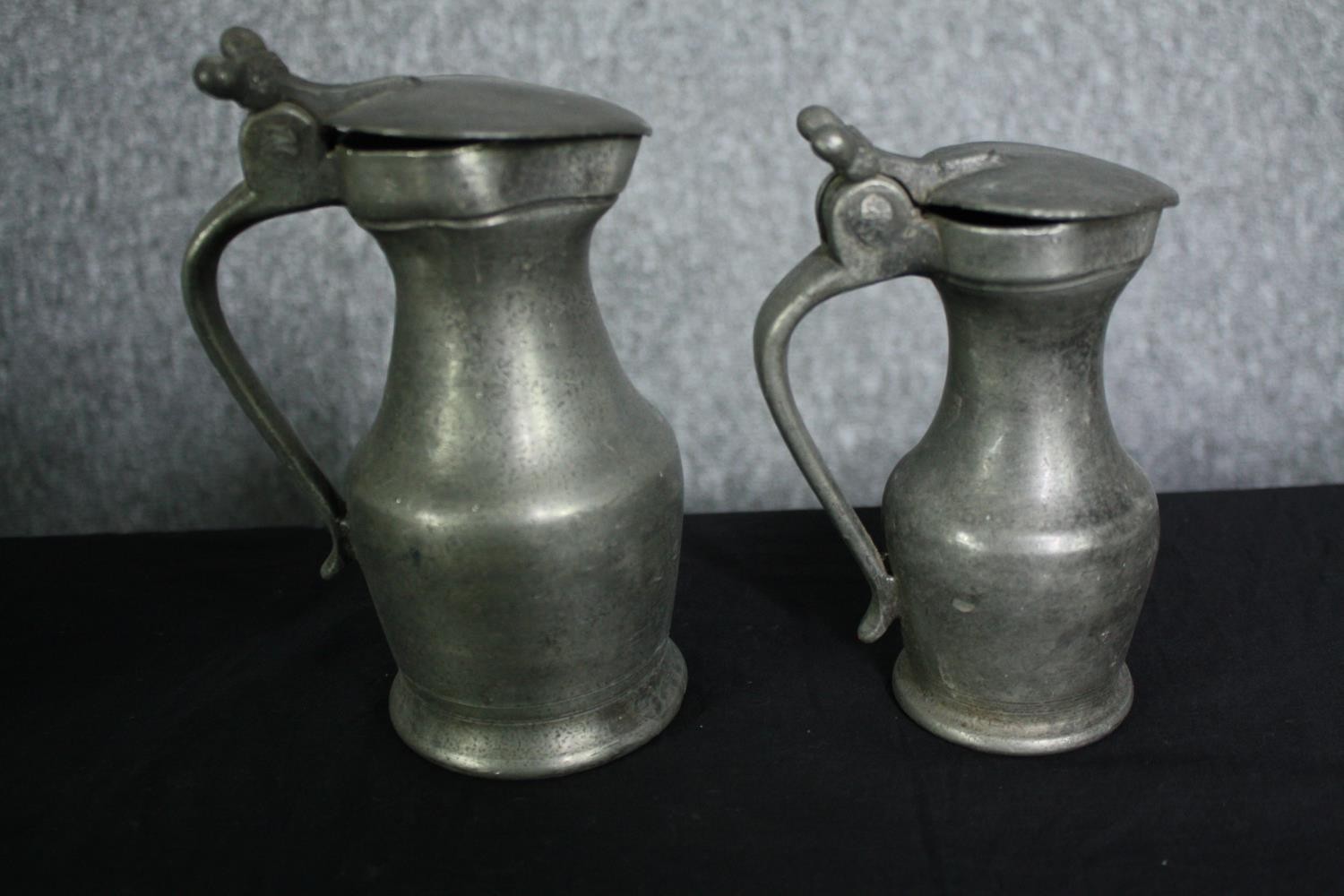 A set of six 19th century graduating pewter lidded jugs. H.27cm. (largest) - Image 5 of 6