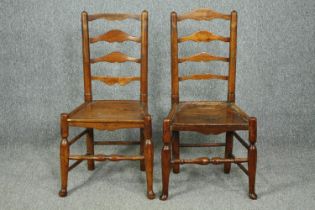 A pair of 18th century elm Lancashire ladderback dining chairs.