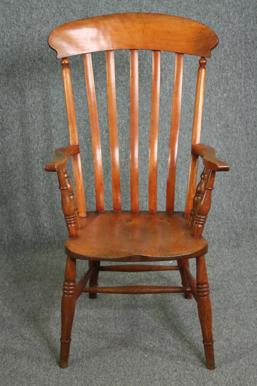 A 19th century elm seated bar back kitchen armchair. H.110cm.