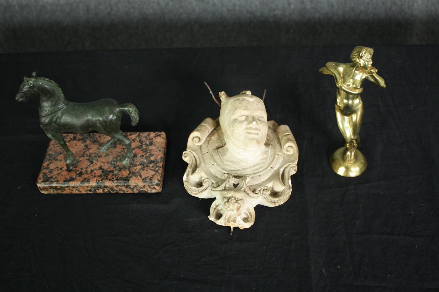 A bronze horse figure, a plaster faun mask and a brass figure. H.18 W.14cm. (largest).