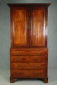 A Georgian mahogany cabinet on chest with estate cupboard fitted interior above brushing slide