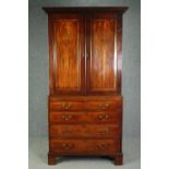 A Georgian mahogany cabinet on chest with estate cupboard fitted interior above brushing slide