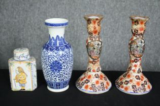 A Delft tea caddy, a Chinese blue and white vase and a pair of Imari candlesticks. H.23cm. (largest)