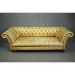 Chesterfield sofa, Victorian style in deep buttoned and studded leather upholstery raised on