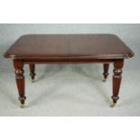 A late Georgian style mahogany extending dining table with two extra leaves and winding handle. H.77