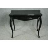 A 19th century ebonised foldover top games table on slender Louis XV style cabriole supports. H.69