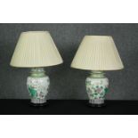 A pair of Chinese Famille Verte style baluster form table lamps with their shades on hardwood bases.