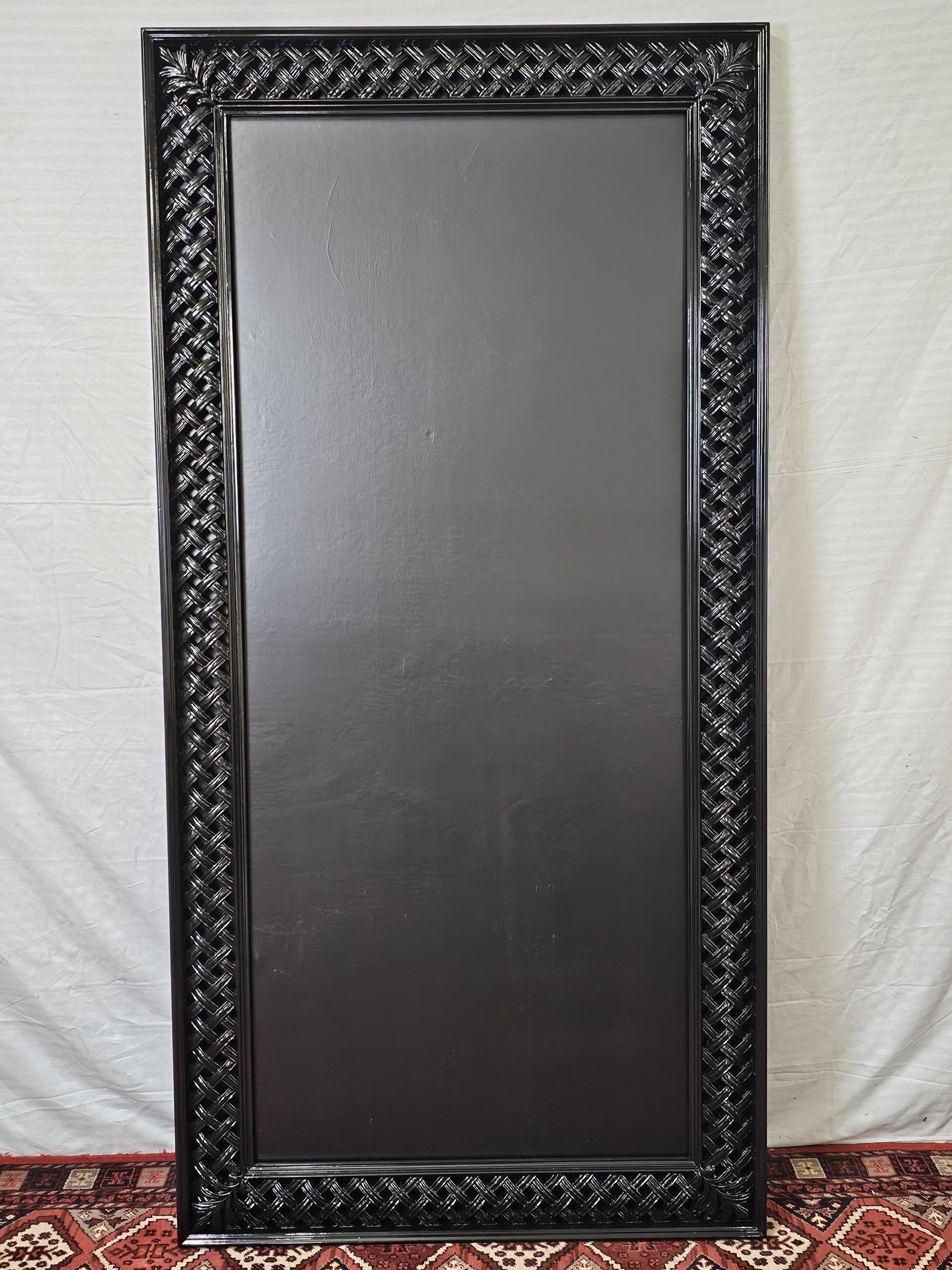 A contemporary carved and lacquered full height mirror. H.200 W.100cm.