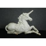 An early 20th century painted cast iron unicorn firedog. H.41 W.60 D.25cm.