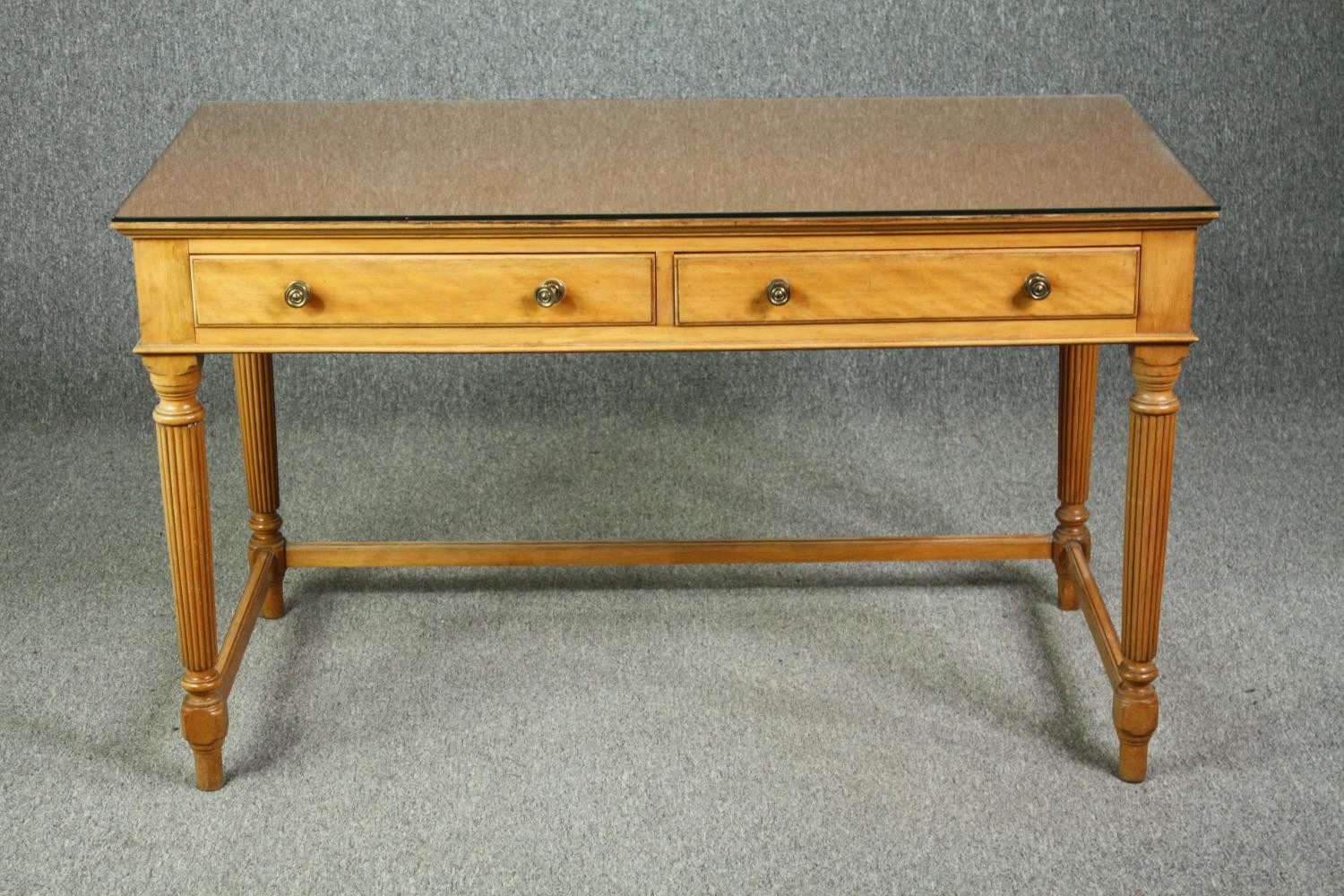 An early 19th century satinwood writing table with composite top under plate glass, stamped