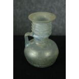 A Roman iridescent glass oil jug. H.12cm.