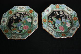A pair of early 20th century Famille noire hand painted octagonal plates with peacock and floral