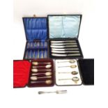 Four cased sets of silverware, six dessert knives with silver blades, a set of six teaspoons, four