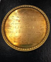 A 19th century French yellow metal (tests higher than 9ct gold) medal with raised edge and inscribed