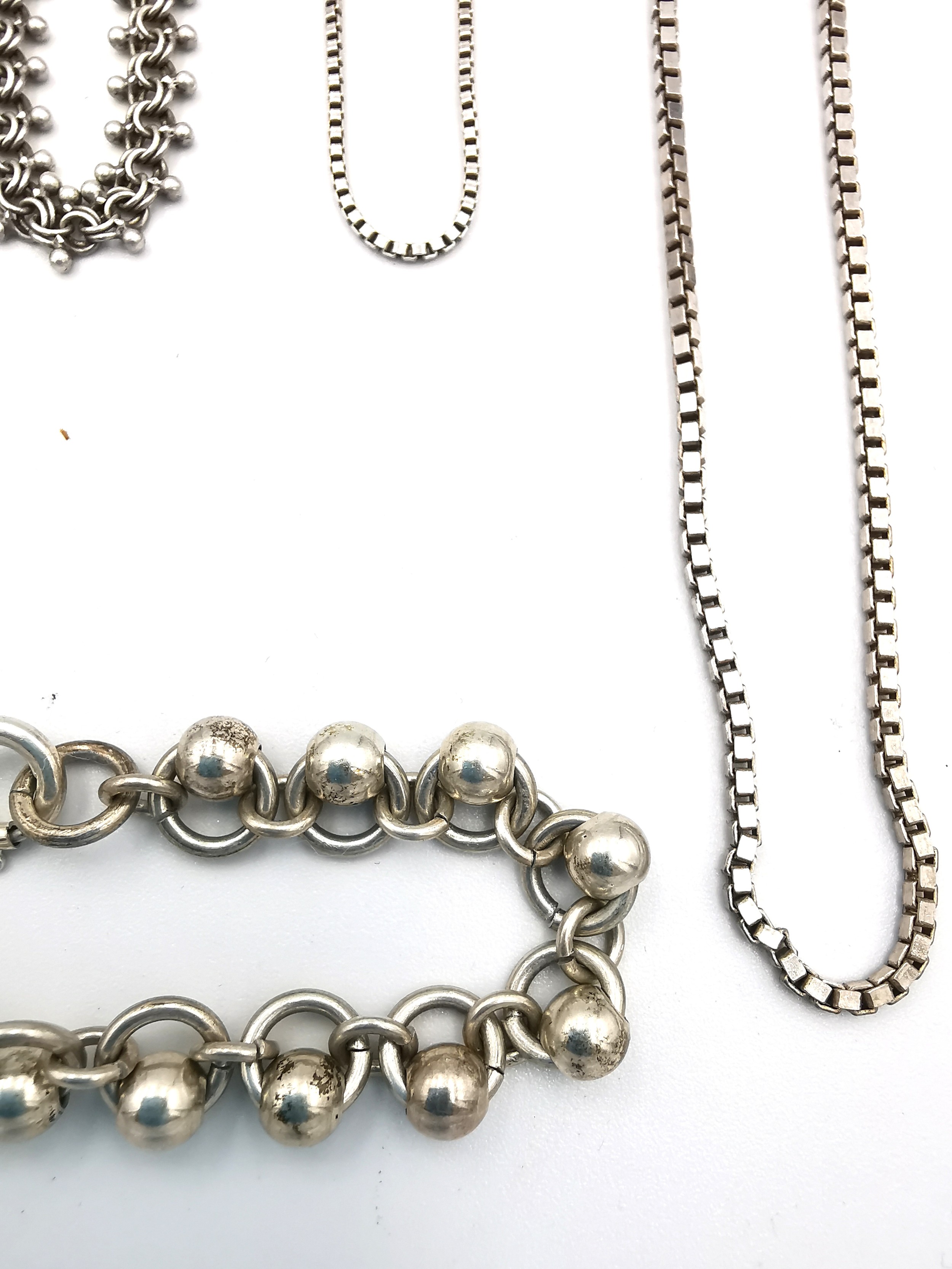 A collection of silver chains of varying length and a white metal rollerball link bracelet. - Image 2 of 4