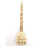 A 19th century Indian carved bone back scratcher in the form of a hand, with inset pink stones.