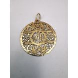 A gold plated pierced mongram pendant with acanthus leaf detailing. Diameter 4cm. Weight 5.06g