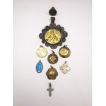 A collection of religious medallions, including a filigree wirework medallion of Mary and Jesus, a