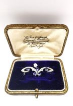 A leather boxed Belle Époque stylised scrolling foliate design white metal (tests as platinum)