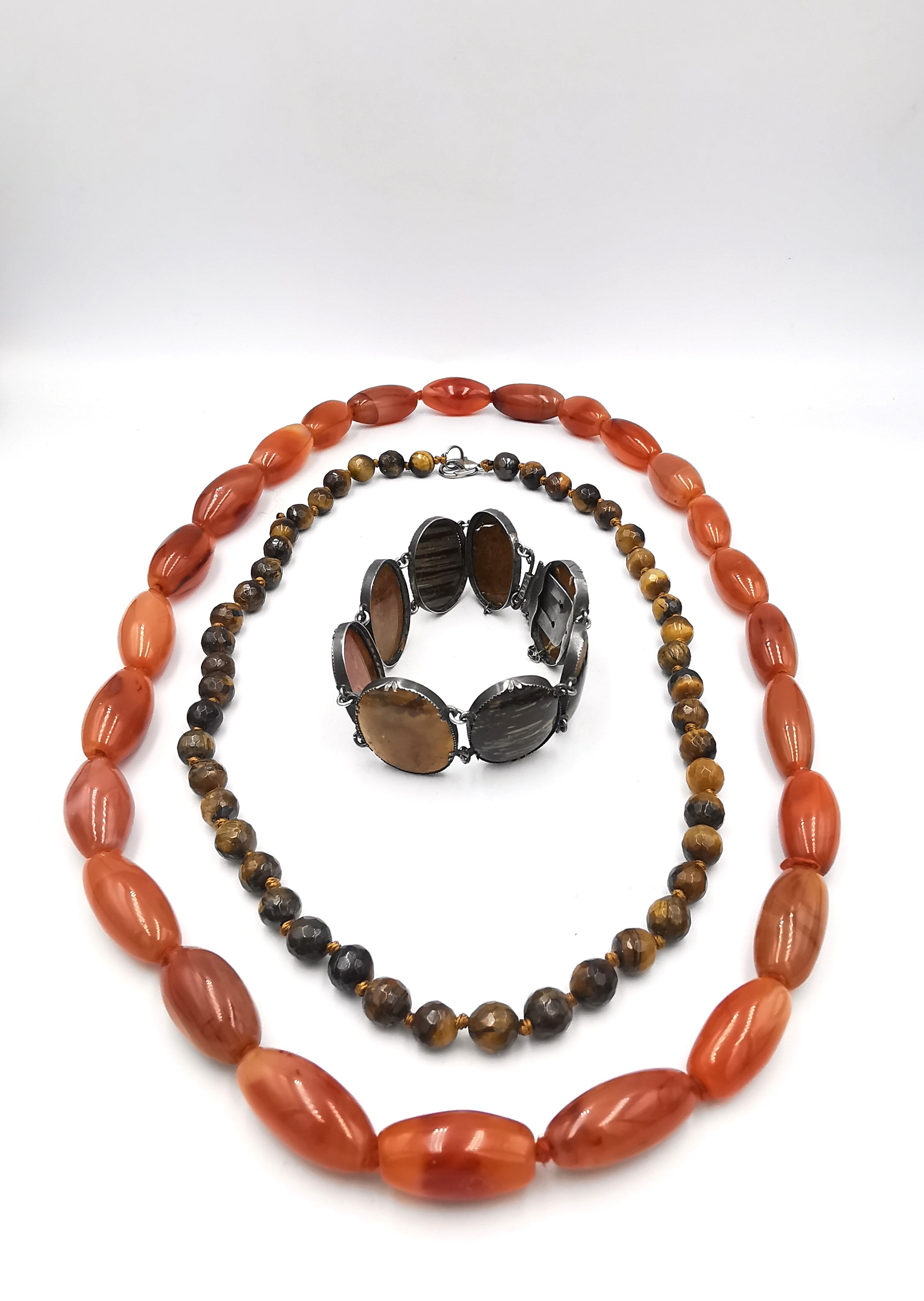 A silver and specimen agate articulated bracelet along with two carnelian and tiger's eye bead