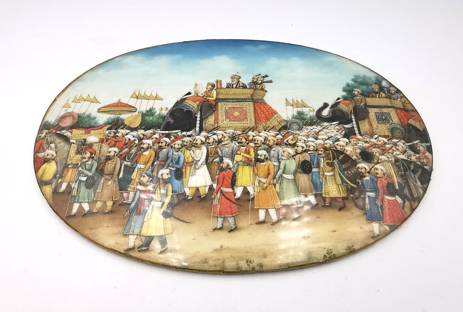 A 19th century Indian Mughal oval miniature on ivory of a royal procession, Akbar Shah II on