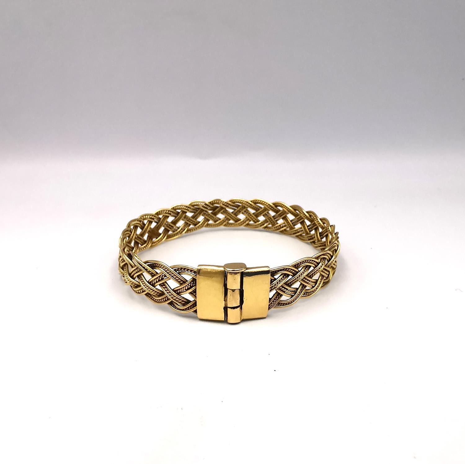 A woven gold plated wirework plaited bracelet with pin fastening. Diameter 6cm. Weight 18.62g.
