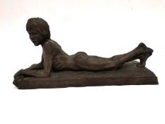 Neil Godfrey, British, b.1937, reclining bronzed resin of a lying naked young male, signed and dated