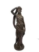 A 19th century bronze sculpture of a classical lady in draping robes removing her head cloth,