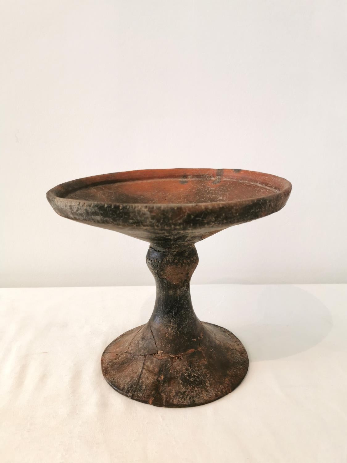 A Pre-Colombian terracotta pedestal dish, with carved and grooved decoration at rim. ( base and