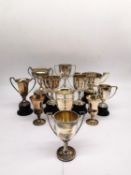 A collection of eleven silver and white metal golfing trophies with winners and competition