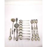 A collection of silver teaspoons, two pairs of sugar tongs, a pickle fork, a small sauce ladle and a