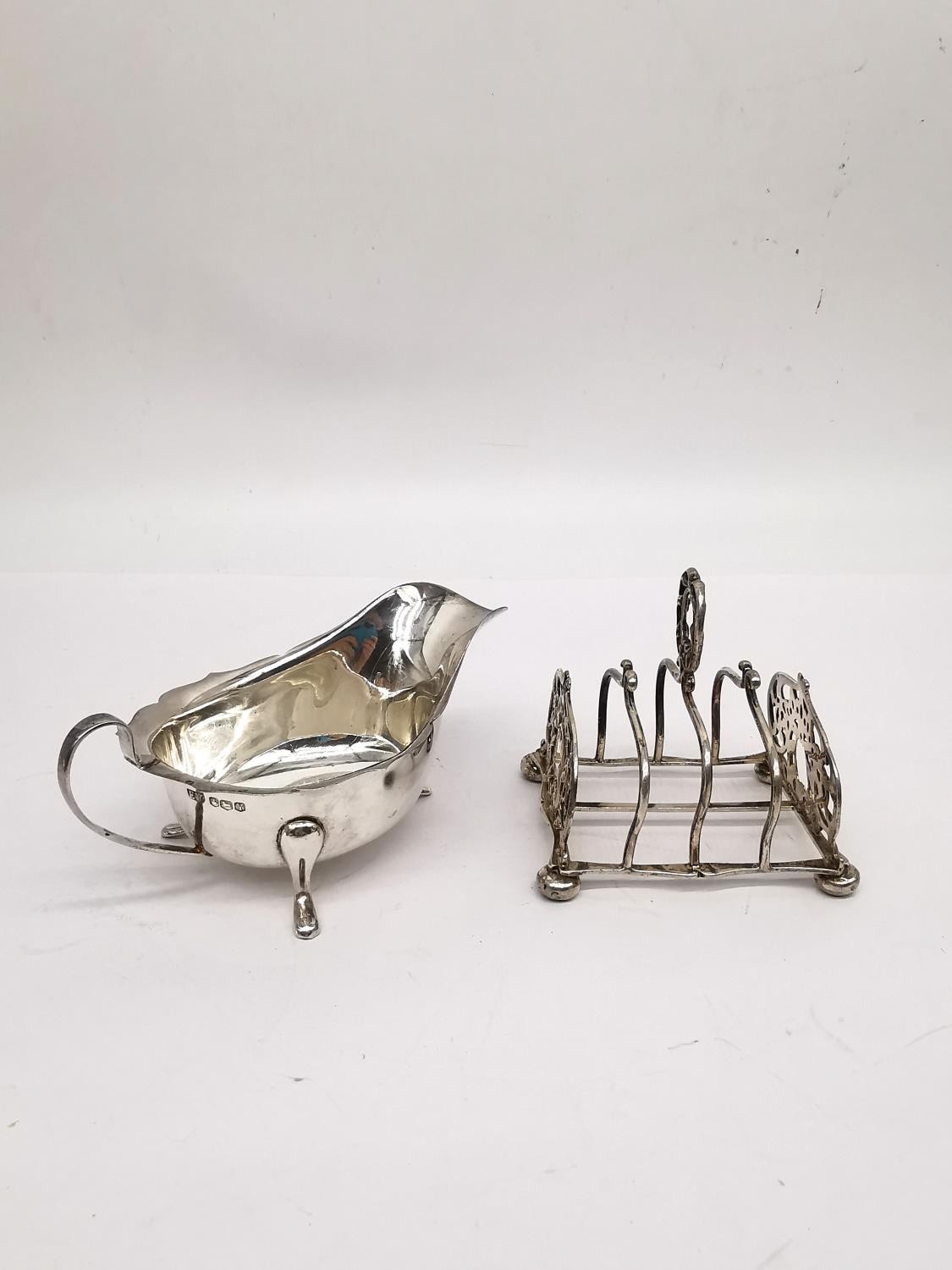 A silver gravy boat by Viners Ltd along with a sterling silver Victorian toast rack by James Dixon &